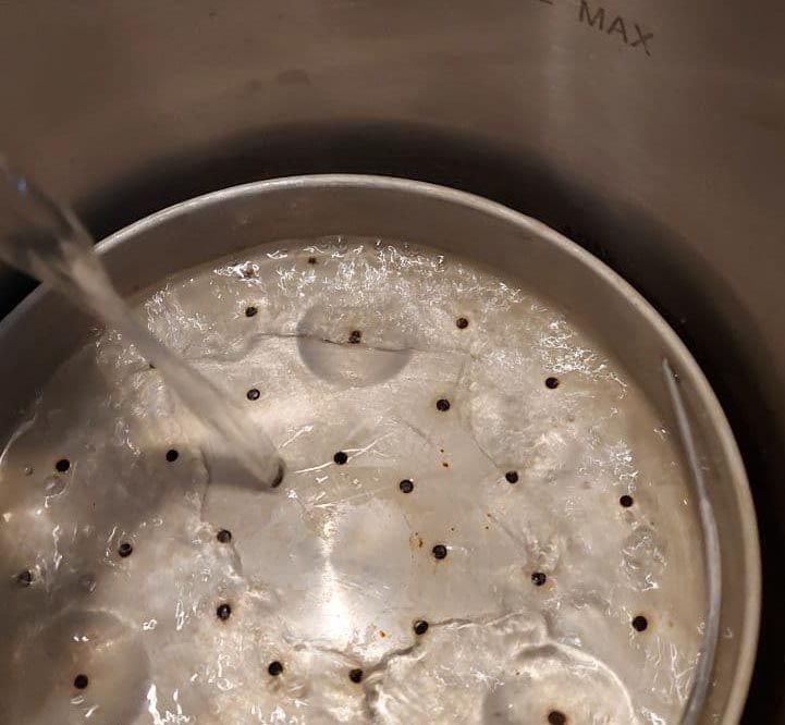 Water being poured into a pressure cooker