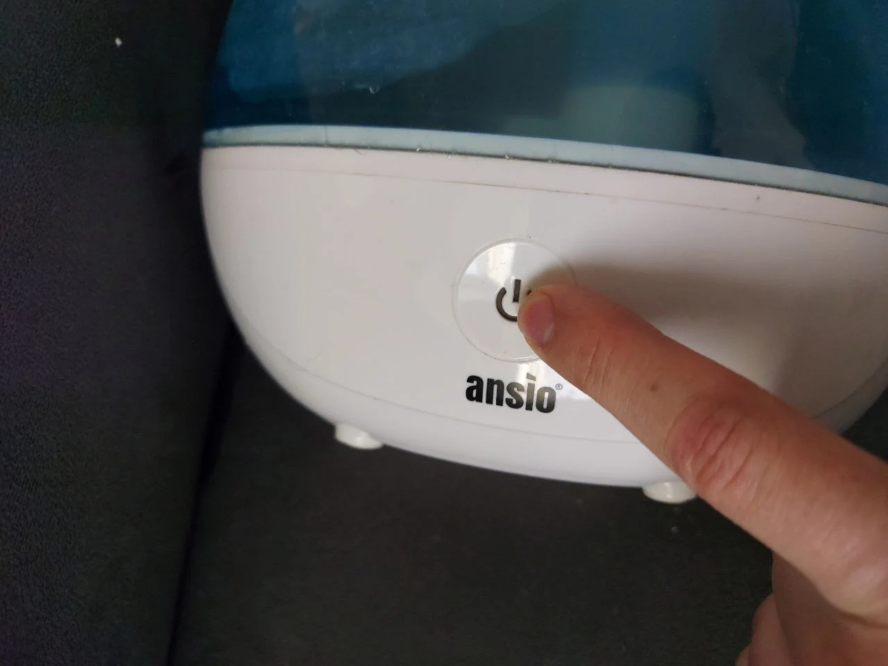 Finger pointing to button on humidifier